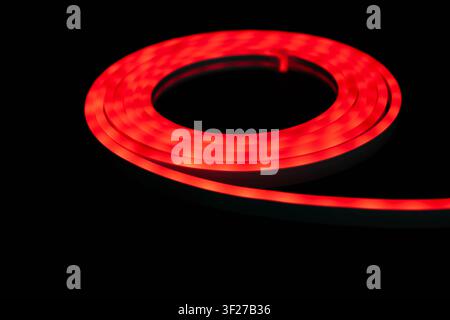 Red LED strip light glowing on black background, flexible neon style lighting Stock Photo