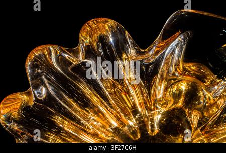 Smooth glass surface. Abstract texture of orange glass on a black background. Stock Photo
