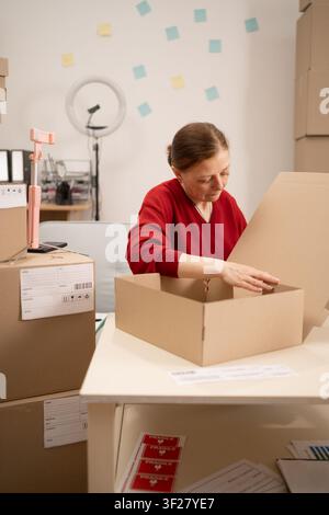 Expertly packing boxes in workspace, efficient business logistics and packaging services. For e-commerce and business ideas Stock Photo