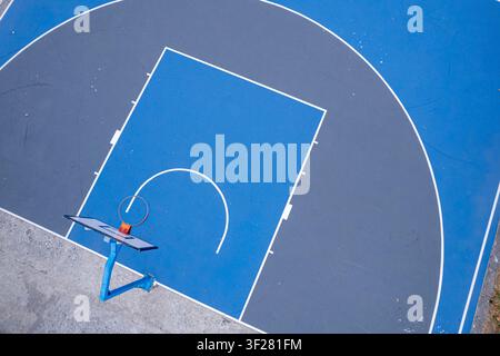 Clean geometric lines on a blue concrete sports court in a public urban park Stock Photo