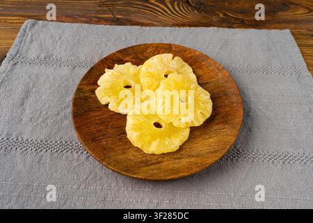 Dry Pineapple Rings on Wood Plate, Candy Pineapples, Dehydrated Yellow Sugar Fruit, Candied Fruits Circles, Dry Pineapple on Rustic Background Stock Photo