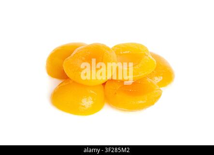 Canned Peaches Pile Isolated, Apricot Halves in Syrup, Yellow Fruit Dessert, Tinned Nectarine Compote, Orange Peeled Peache Slices on White Background Stock Photo