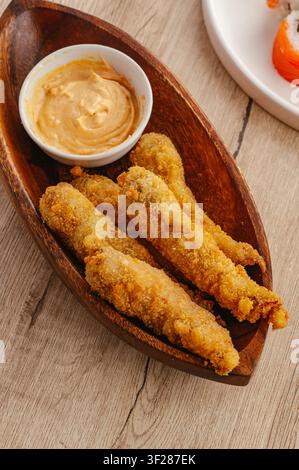 Crispy breaded fish fingers with creamy sauce Stock Photo