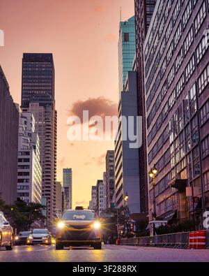 Yellow taxi drives down a New York City street Stock Photo