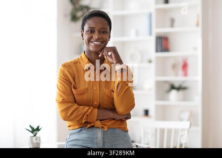 Smiling Black Female Professional Standing In Office With Crossed Arms, Business Concept Stock Photo