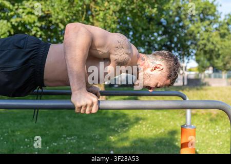 Man doing calisthenics push ups outdoor training Stock Photo