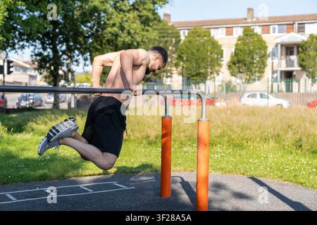 Man doing calisthenics tricep dips on parallel bars Stock Photo