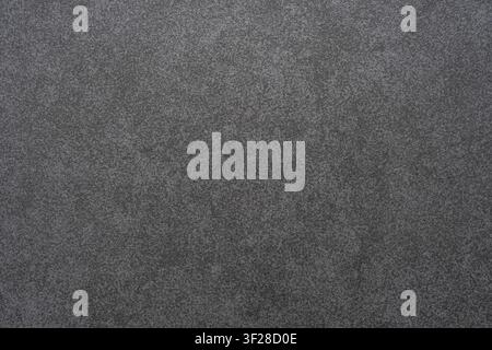 Fine texture of dark grey matte sandpaper sheet with abrasive grain surface. Stock Photo