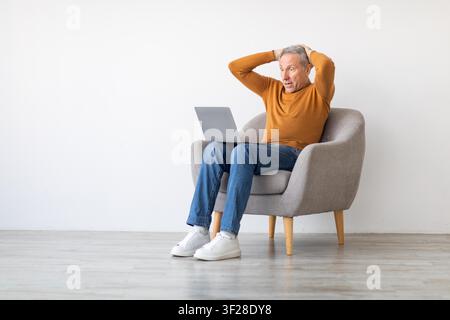 Worried Elderly Caucasian Man Using Laptop At Home, Digital Stress Concept Stock Photo
