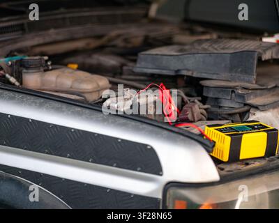 starting a car with a weak battery using a portable booster, no people Stock Photo