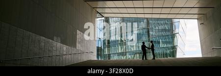 Businessmen Shaking Hands in Modern Office Lobby for Partnership Stock Photo