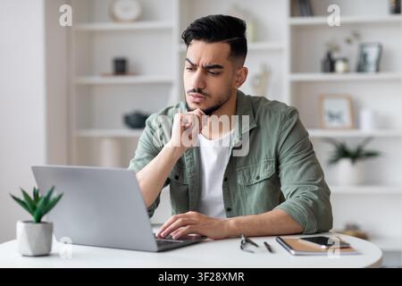 Focused Young Man Working On Laptop In Office, Weight Loss Concept Stock Photo