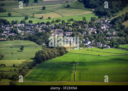 An elevated view of Castleton village nestled among green fields and dry stone walls, captured from Mam Tor in the Peak District, England Stock Photo