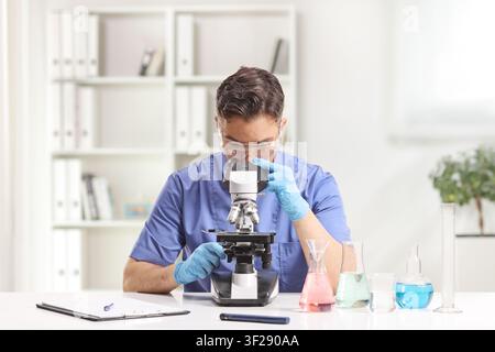 Laboratory technician looking through a microscope Stock Photo