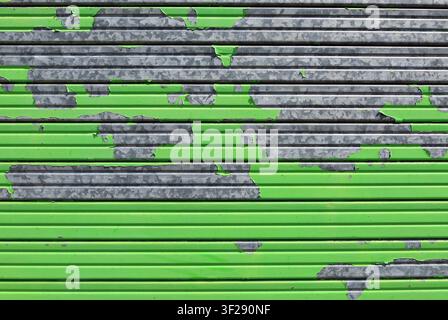 Peeled green metallic alloy garage door shutter. Full frame. background and texture Stock Photo