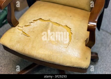 old armchair seat with torn down leather, indoor close up Stock Photo