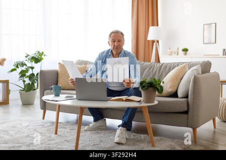 Elderly Caucasian Man Working On Laptop At Home, Analyzing Charts And Reports, Business Concept Stock Photo