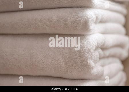Neatly folded white hotel towels in a modern luxury hotel bathroom, symbolizing comfort, cleanliness and relaxation Stock Photo