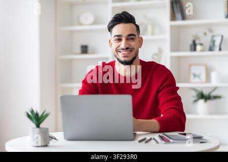Smiling Young Man Working On Laptop In Modern Office, Business Concept Stock Photo