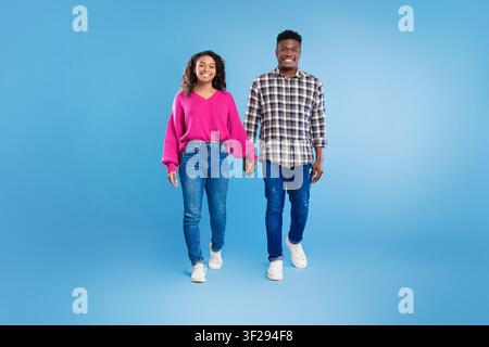 Happy Young African American Couple Walking Hand In Hand, Studio Background, Lifestyle Concept Stock Photo