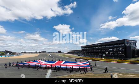 Armed forces personnel carrying a large Union flag at Silverstone for the start of the British Grand Prix race Stock Photo