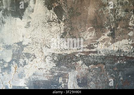 Abstract grunge background with rough textured beige plaster, weathered dark concrete surface, and scratches. Stock Photo