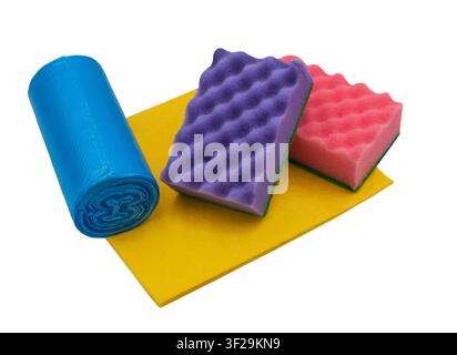 A set of household cleaning supplies, including sponges, a cloth, and a roll of trash bags, on a white background Stock Photo