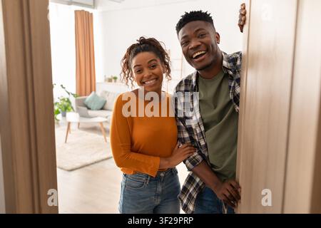 Happy Young African American Couple Smiling While Standing In Doorway At Home Stock Photo
