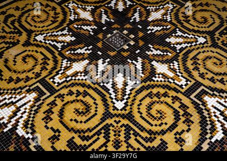 Close up of decorative gold mosaic tile pattern with floor drain, luxury hammam spa flooring with black and gold pattern design Stock Photo