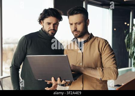 Two Men Analyzing Business Data Together In Modern Office, Business Concept Stock Photo