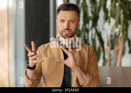 Man With Beard Engaging In Conversation, Modern Office Environment, Business Concept Stock Photo