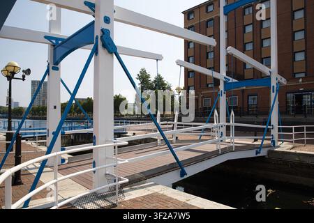 A close-up view of the structural framing and white railings of a blue and white pedestrian bridge at Salford Quays, Salford, Manchester, UK. Stock Photo