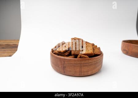 Rye Croutons in Wood Bowl Isolated, Homemade Brown Bread Rusks, Crispy Bread Cubes Scattered Pile, Dry Rye Crouoton Crumbs, Brown Roasted Salted Crack Stock Photo