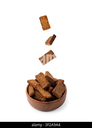 Bread croutons in air isolated on white background side view. Crispy rye bread cubes falling, fly dry rye crumbs, levitate rusks, crouoton or white ro Stock Photo