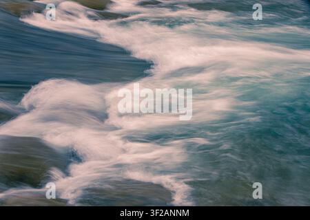 water in motion creates an interesting background, blurred with camera motion. Stock Photo