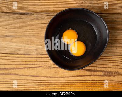 Two Broken Eggs in Bowl Isolated, Raw Yolk and White, Fresh Broken Organic Chicken Eggs on White Background Stock Photo
