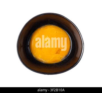 Beaten Egg Yolks in Bowl, Fresh Chicken Eggs for Cooking Recipe, Mixed Organic Yolks in Black Bowl Stock Photo