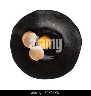 One Broken Egg in Black Bowl, Raw Yolk and White, Fresh Broken Organic Chicken Egg on Wooden Rustic Background Stock Photo