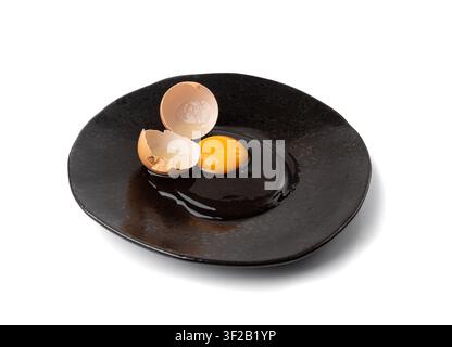 One Broken Egg in Black Bowl, Raw Yolk and White, Fresh Broken Organic Chicken Egg on Wooden Rustic Background Stock Photo
