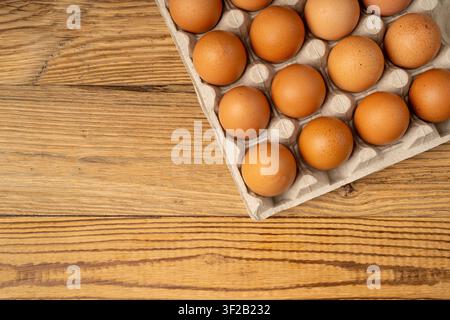 Egg Tray on Wooden Rustic Background, Twenty Brown Eggs Pack, 20 Fresh Organic Eggs in Paper Container Stock Photo