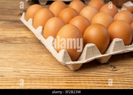 Egg Tray on Wooden Rustic Background, Twenty Brown Eggs Pack, 20 Fresh Organic Eggs in Paper Container Stock Photo