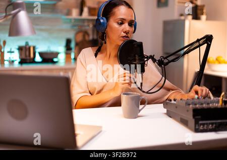 Host records new podcast series at home, capturing recording, streaming and digital media production inside a home studio recording setup. Stock Photo