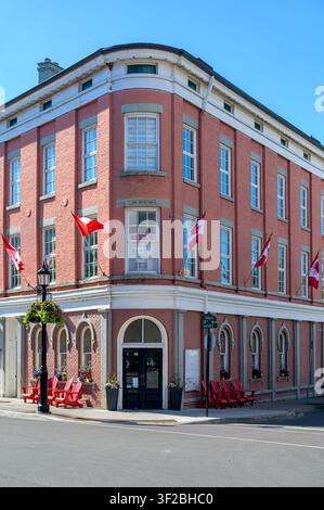 Historic corner brick building with Canadian flags and preserved heritage architecture. Stock Photo