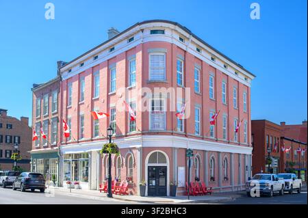 Historic corner brick commercial building with Canadian flags and heritage architecture. Stock Photo