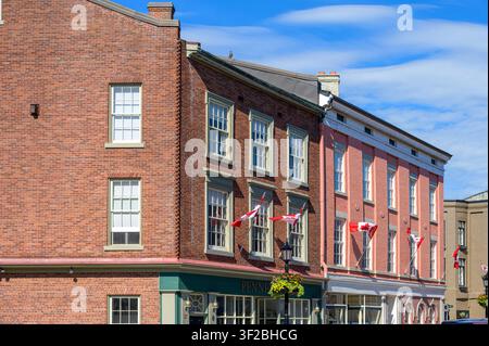 Brick commercial buildings with Canadian flags lining a restored nineteenth-century main street. Stock Photo