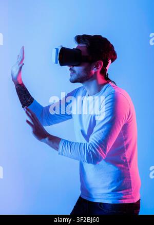 Millennial man in 3D glasses in neon Stock Photo