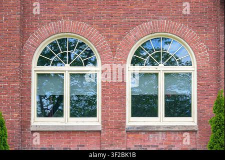 Symmetrical arched windows on historic red brick civic building. A detail of the Admistritive Offices of the Port Hope Municipality. Stock Photo