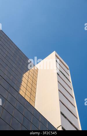 A minimalist architectural composition featuring contrasting modern buildings under a clear blue sky in George Town, Penang, Malaysia. Stock Photo