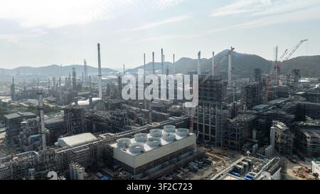 An extensive petrochemical refinery facility featuring complex metallic piping systems and heavy industrial machinery in si racha chonburi thailand. Stock Photo