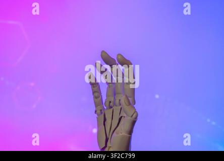 Mechanical hand reaching upward against a vibrant neon pink and blue gradient background. Artificial intelligence, virtual reality, futuristic Stock Photo